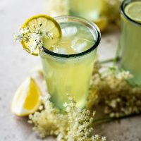 Three glasses of elderflower lemonade with ice.