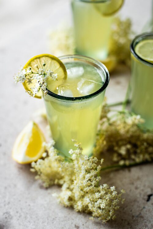 Three glasses of elderflower lemonade with ice.