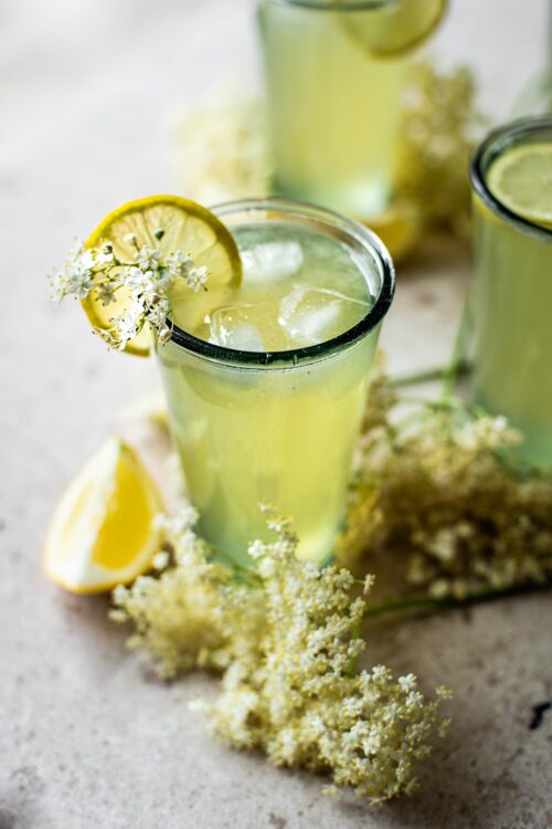 Three glasses of elderflower lemonade with ice.