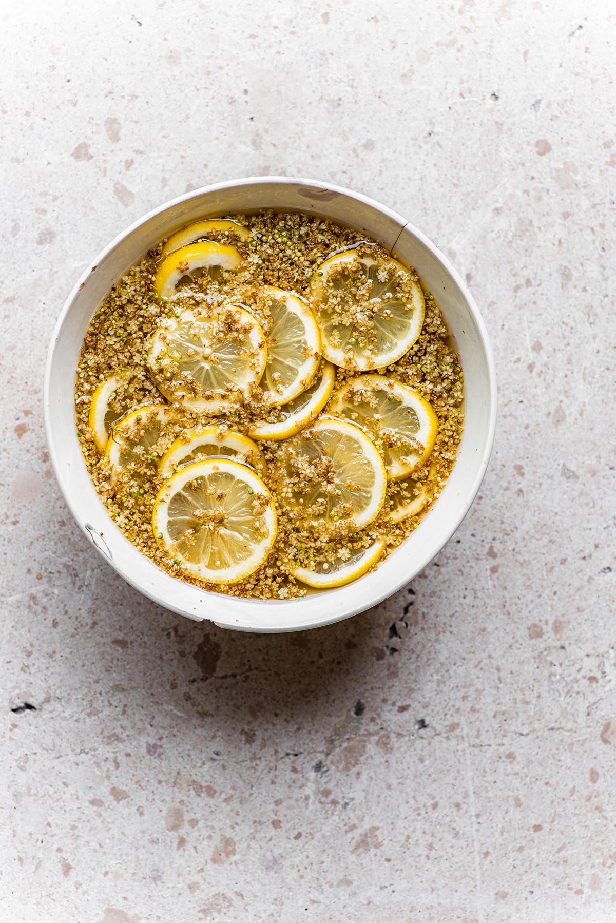 Lemon slices with elderflowers floating in a bowl.