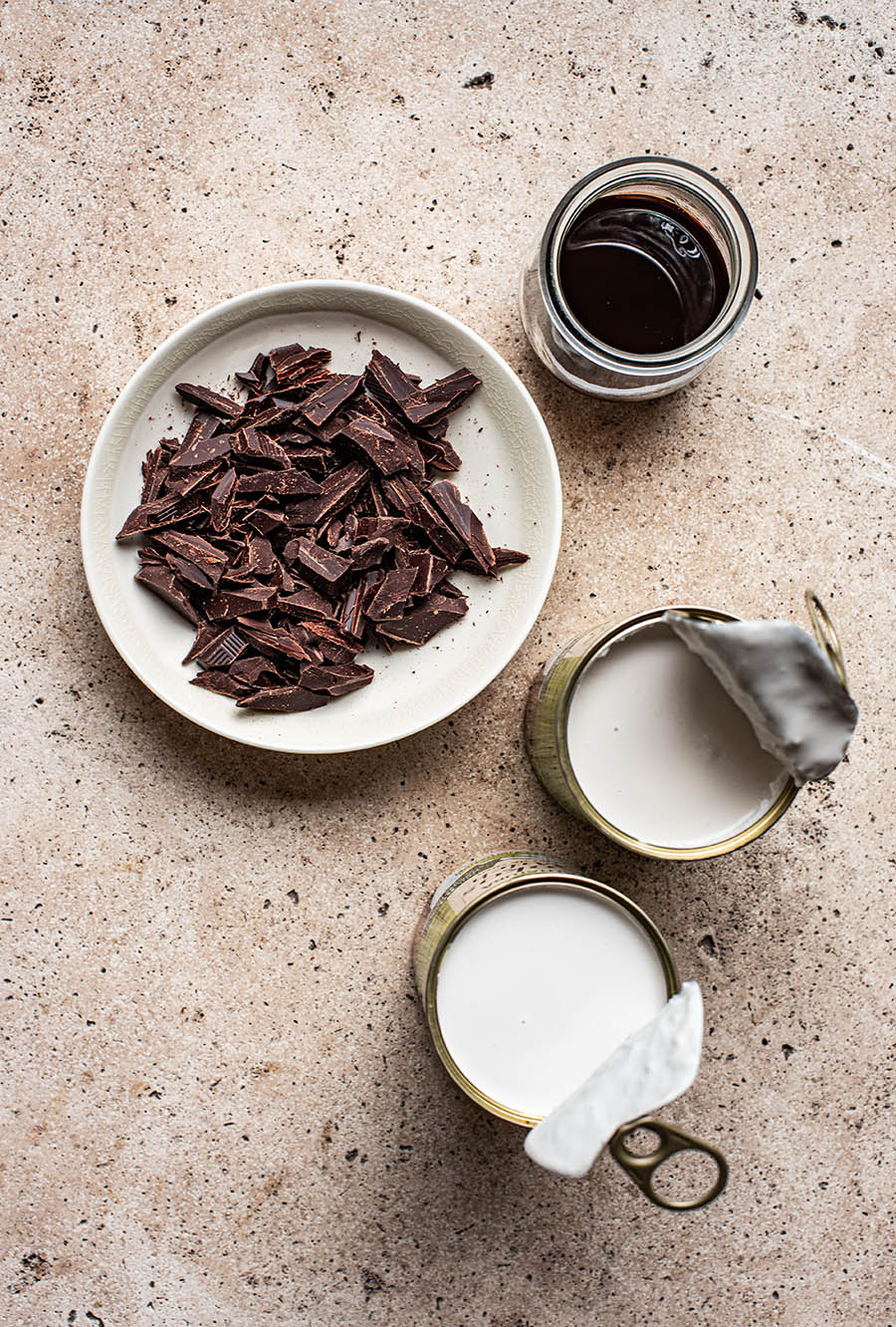 Vegan chocolate ice cream ingredients: dark chocolate, date syrup, and coconut milk.
