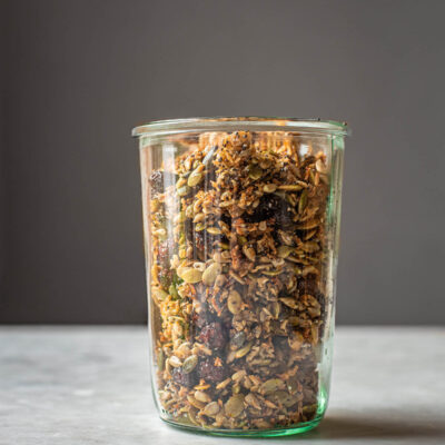 Grain free granola with dried cranberries in a jar, front view.