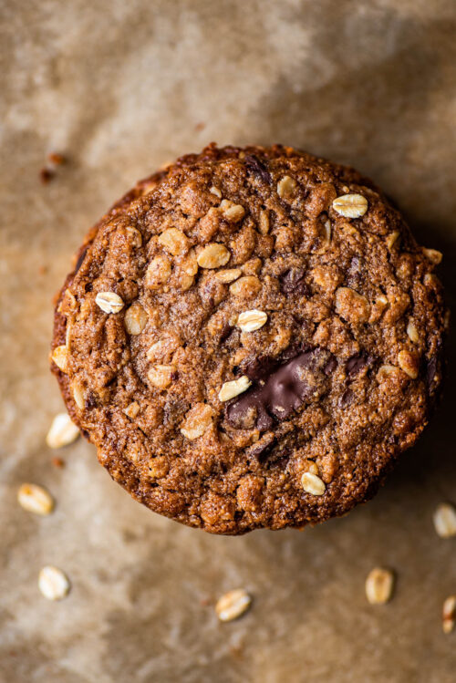 A stack of oatmeal chocolate chunk cookies on parchment paper, top down view.