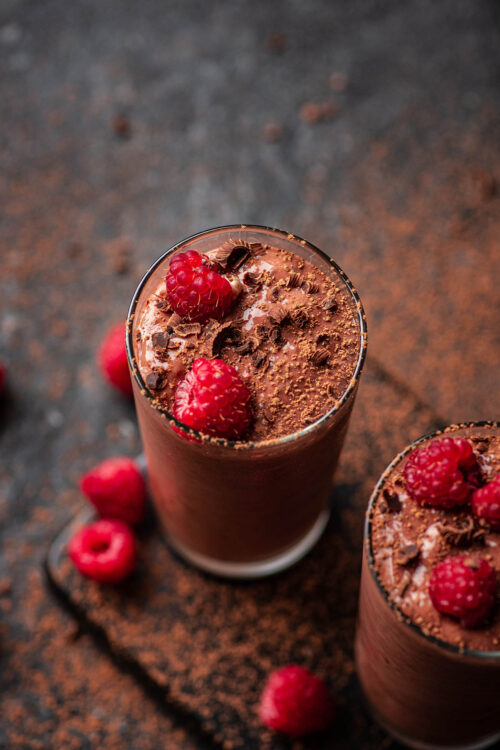 Chocolate raspberry protein shakes topped with chocolate and berries.