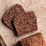 Two slices of dark rye bread with oats cut from a loaf.