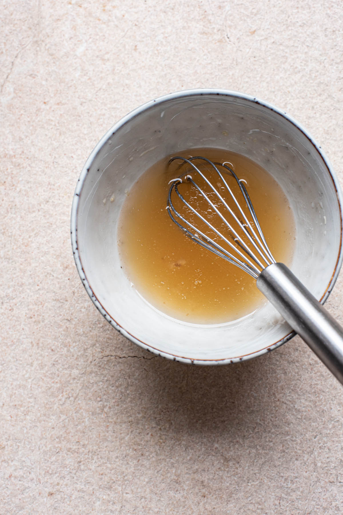 Honey mixture for cookies in a small ceramic bowl.
