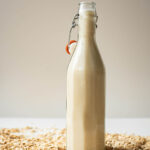 Oat milk in a flip-top glass bottle.