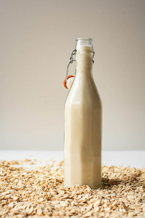 Oat milk in a flip-top glass bottle.