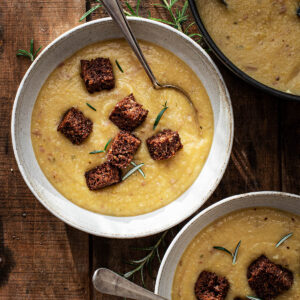 Bowls of cauliflower potato soup topped with rye croutons.