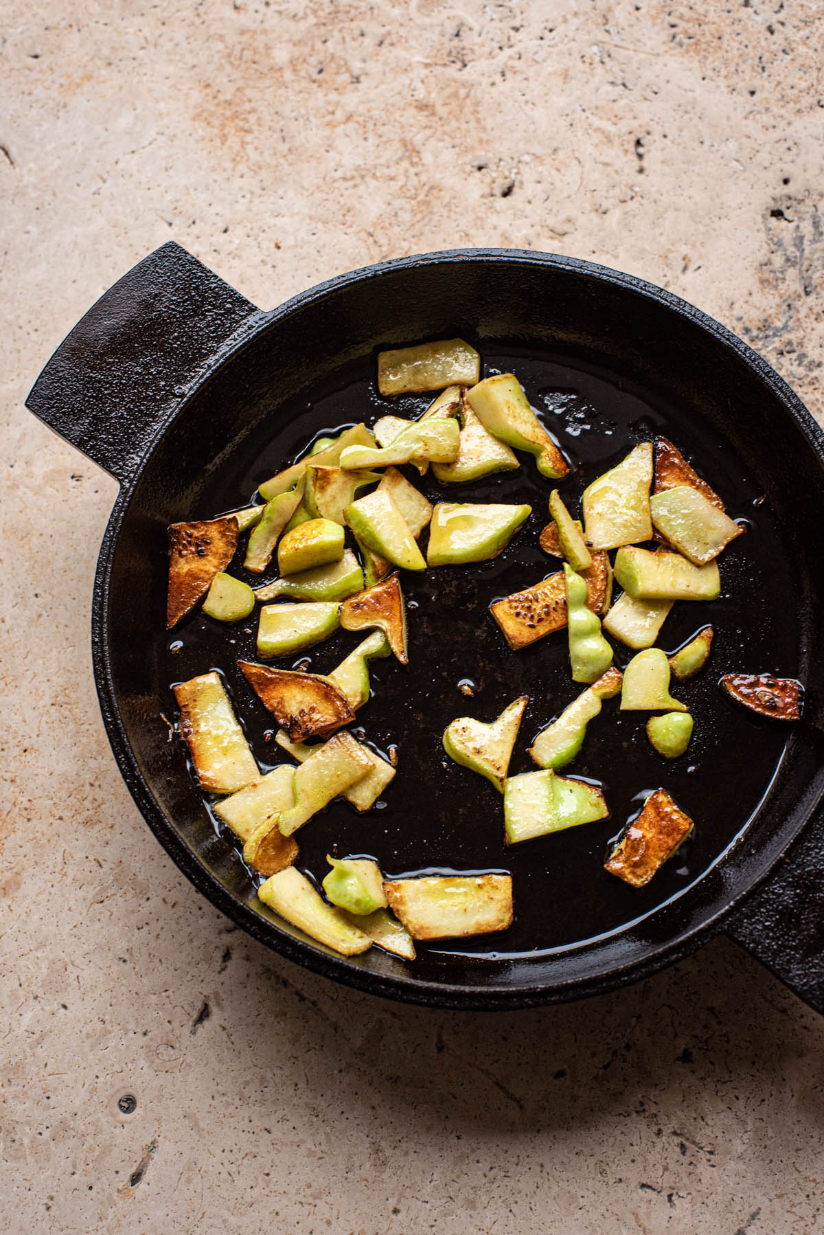 Fried zucchini in a cast iron pan.