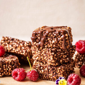 Stack of three puffed quinoa bars with chocolate.