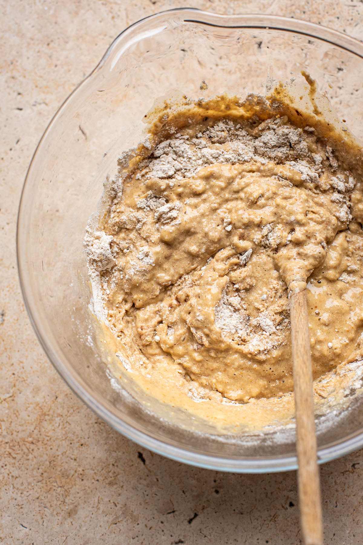 Gluten free banana bread batter partly mixed in a large bowl.
