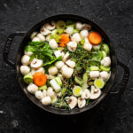 Vegetables and water in a pot before cooking.