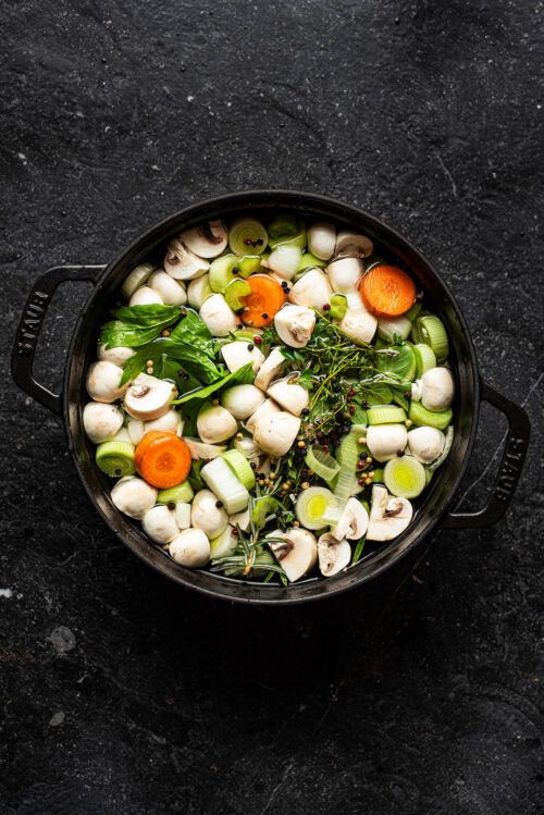 Vegetables and water in a pot before cooking.