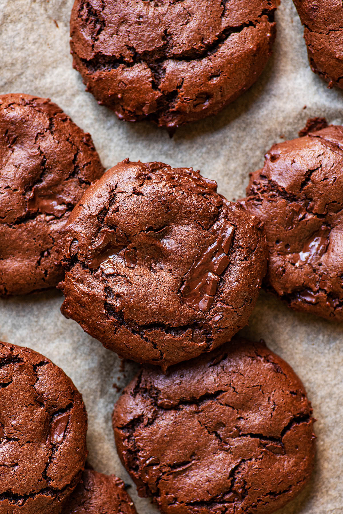 Chocolate cookies piled on a baking sheet.