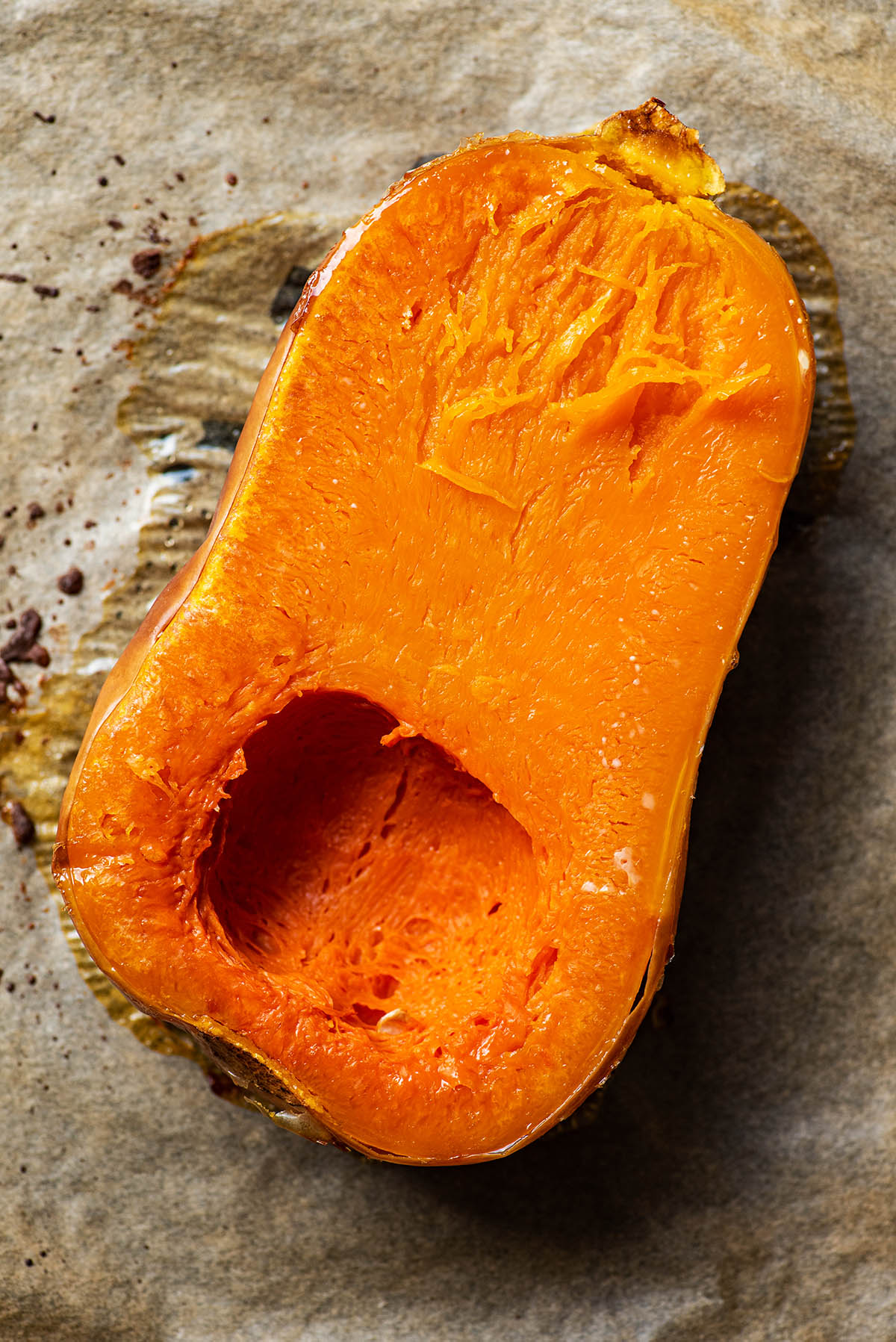 A halved butternut squash, roasted and flipped to show interior.