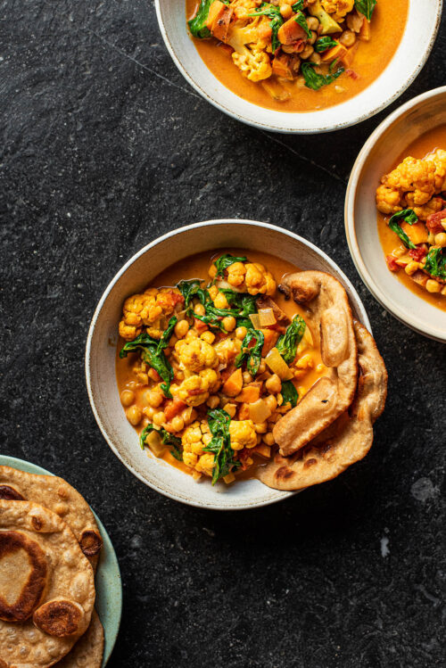 Bowls of curry with naan.