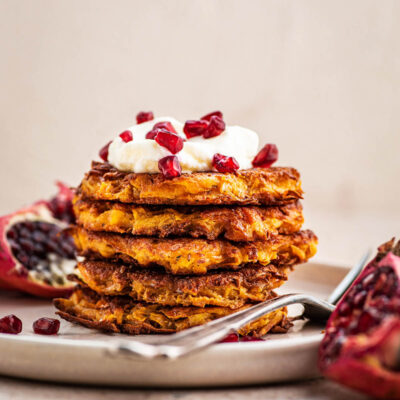 Stack of latkes on a plate with a fork.