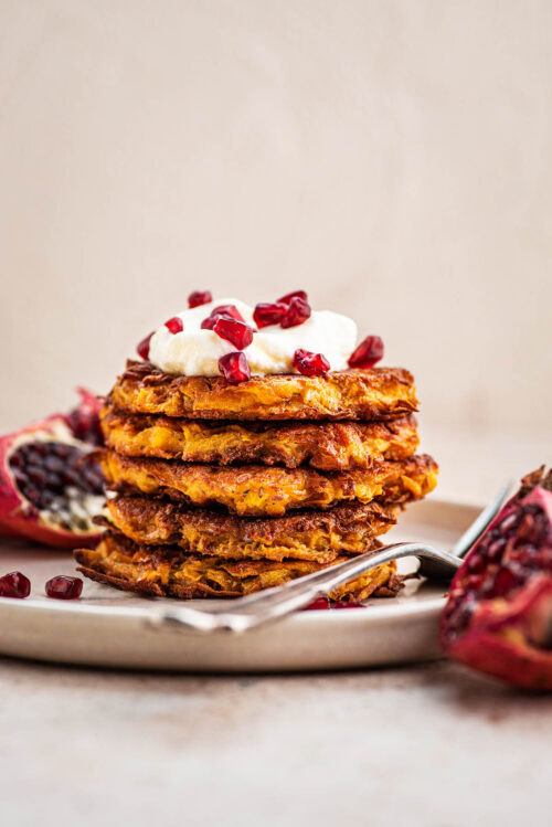 Stack of latkes on a plate with a fork.