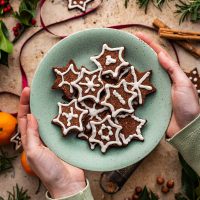 Woman's hands holding a plate of cookies.