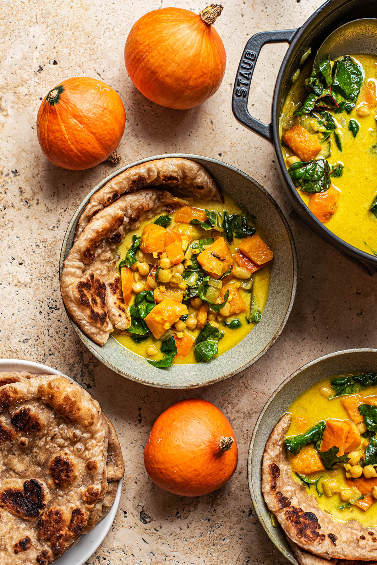 Bowls of pumpkin curry with naan.
