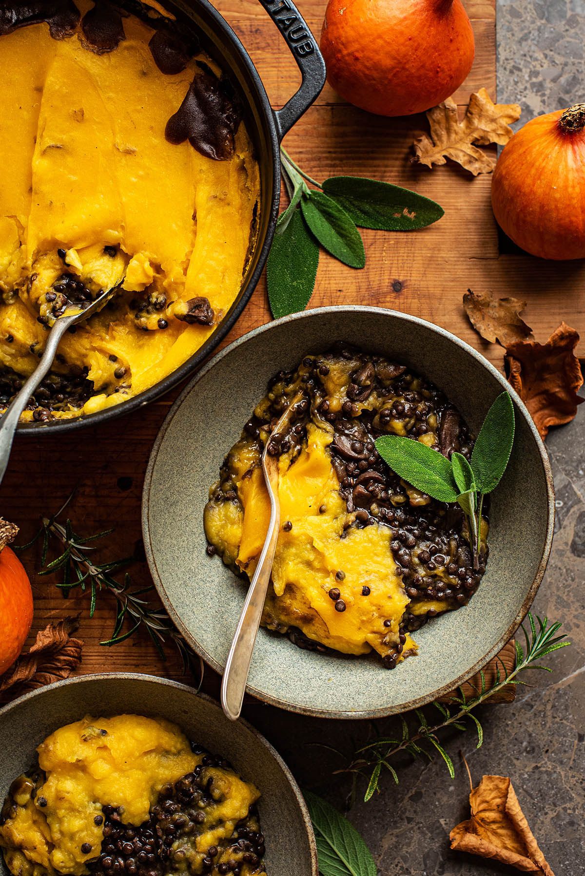 A bowl of shepherd's pie topped with some fresh sage.