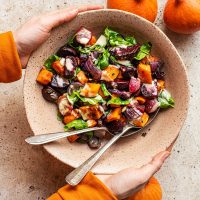 Woman's hands holding the large bowl of salad.