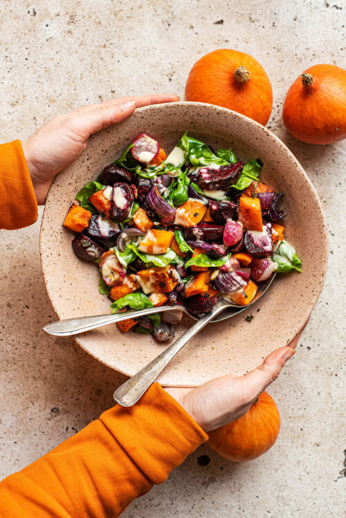 Woman's hands holding the large bowl of salad.