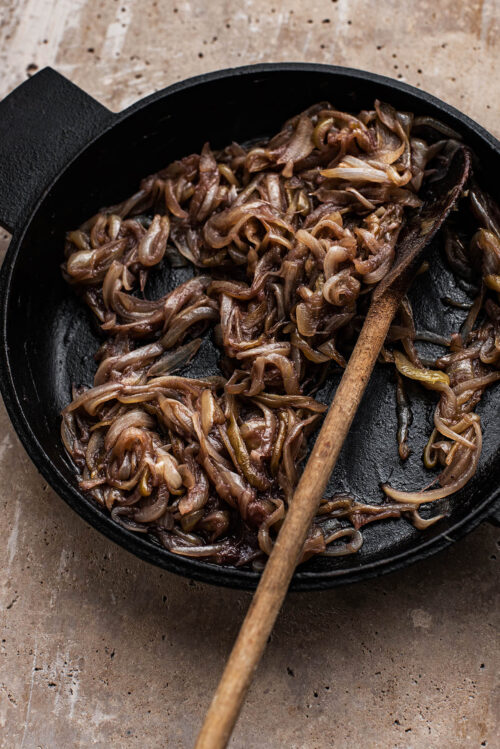 Red wine caramelised onions in a cast iron pan.