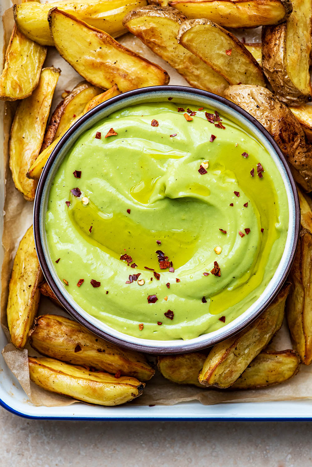 Aioli in a dish with potato wedges.