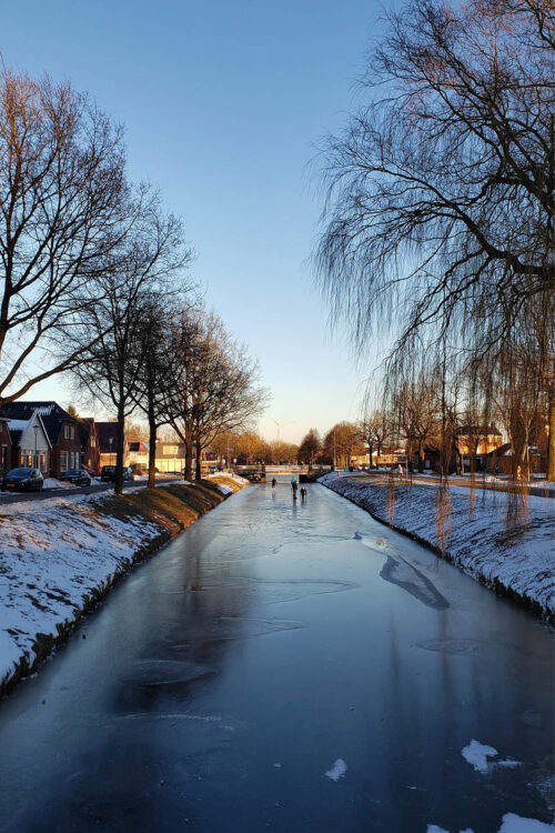 People skating on a frozen canal.