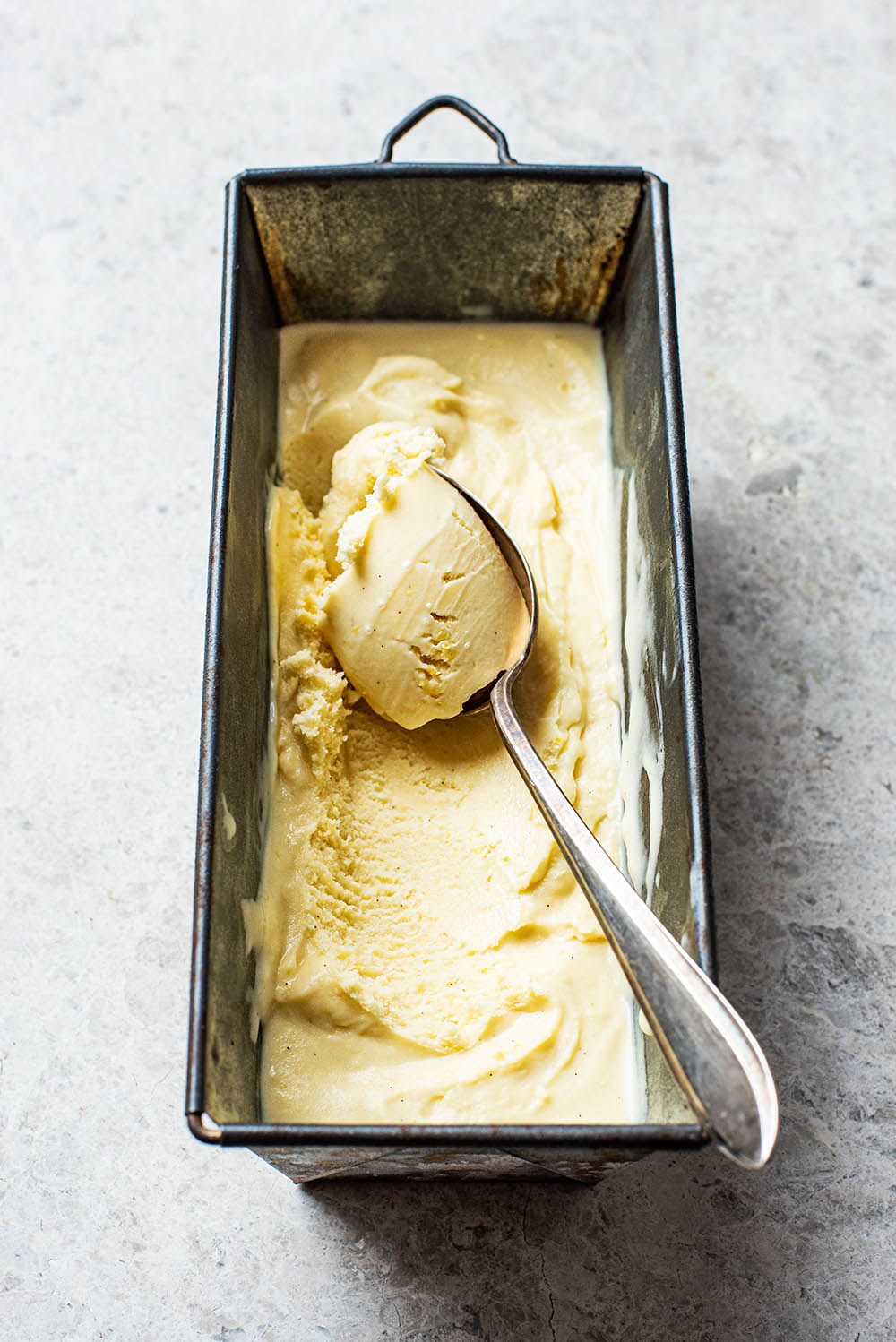 An old silver spoon in the tin with ice cream.