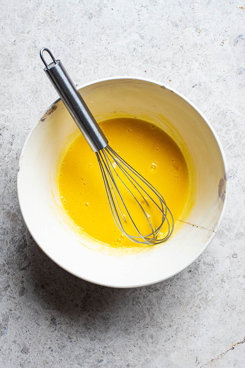 Whisked egg yolks in a bowl.
