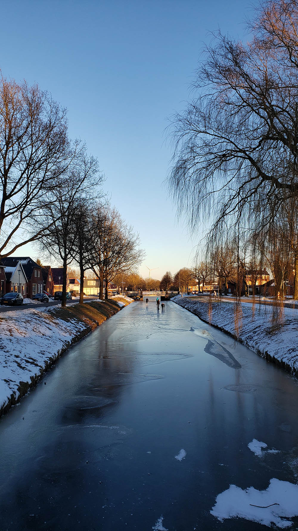 People skating on a frozen canal.