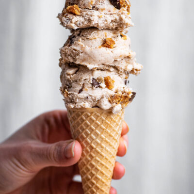 Three scoops on ice cream on a small sugar cone.
