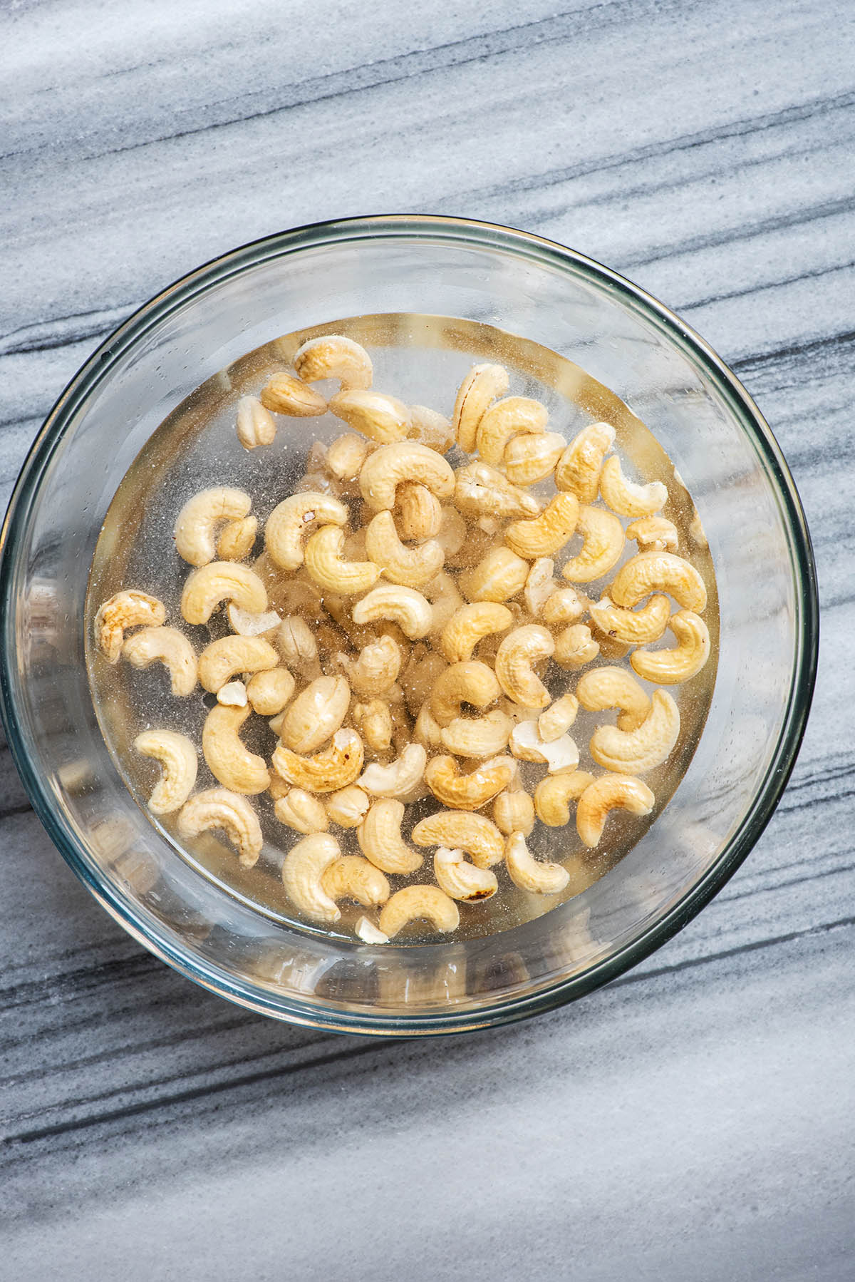 Cashews covered with water in a large bowl.