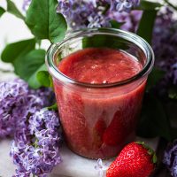 Compote in a jar with lilacs surrounding.