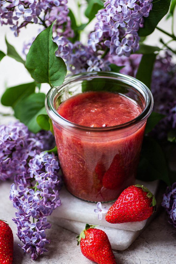 Compote in a jar with lilacs surrounding.