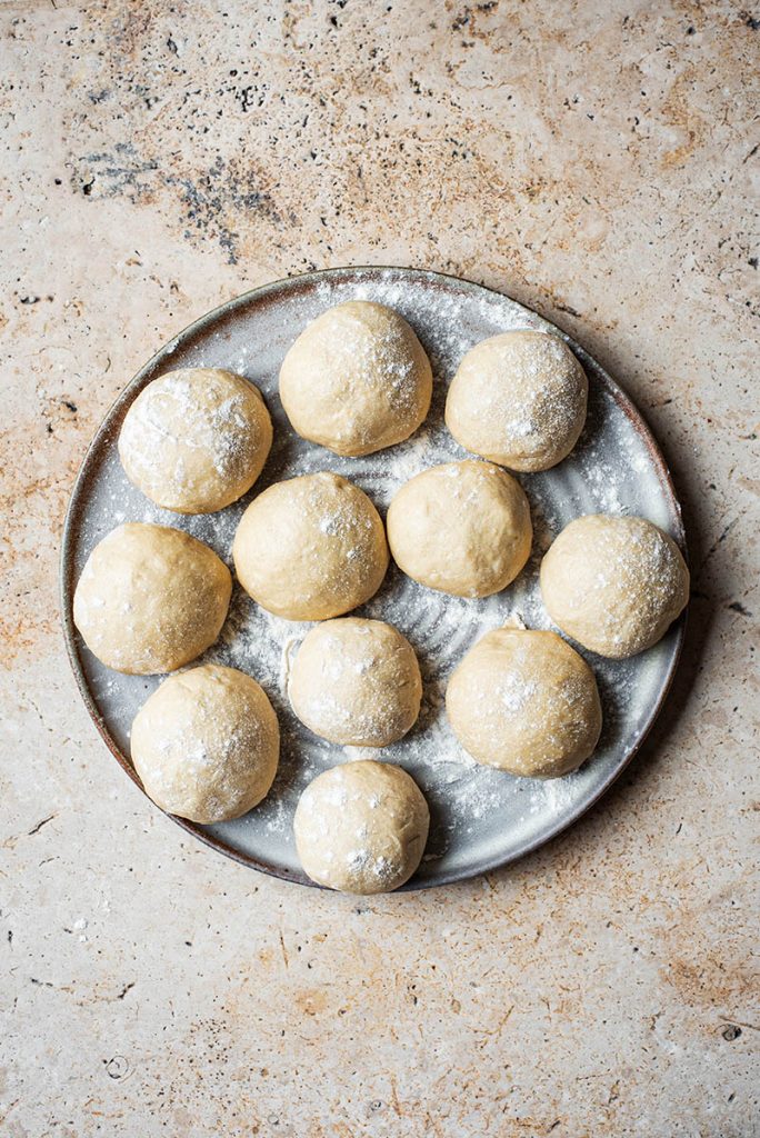 Balls of dough resting on a large plate.