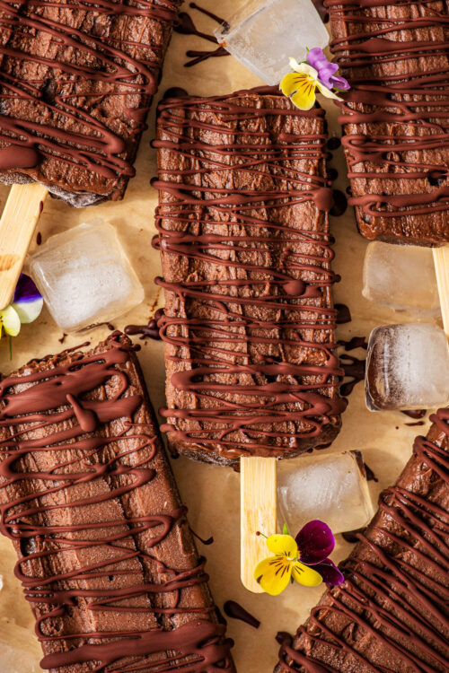 Fudgesicles drizzled with dark chocolate, with ice cubes and pansies.