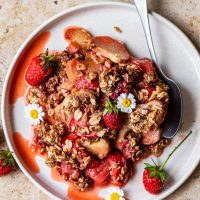 Top down view of a plate with crisp, fresh berries, and flowers.