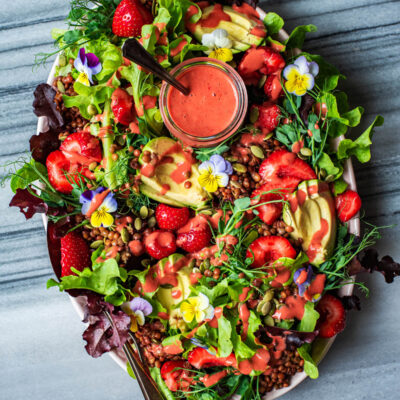Salad on a platter with vinaigrette added.