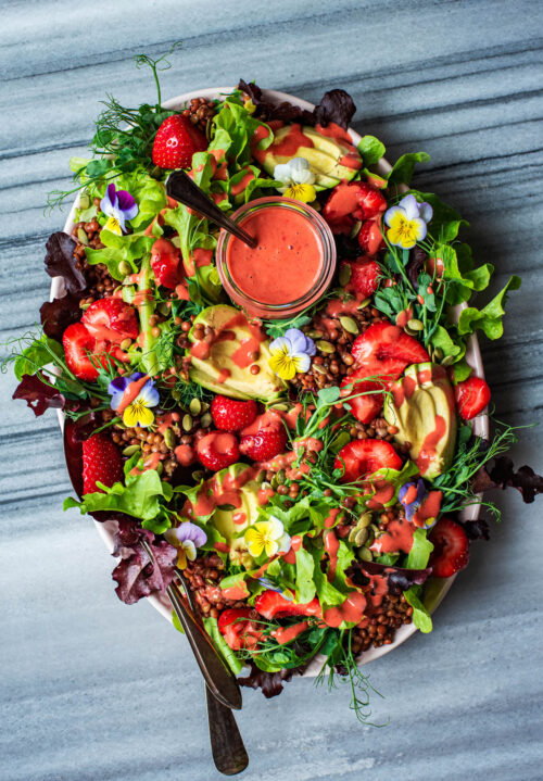 Salad on a platter with vinaigrette added.