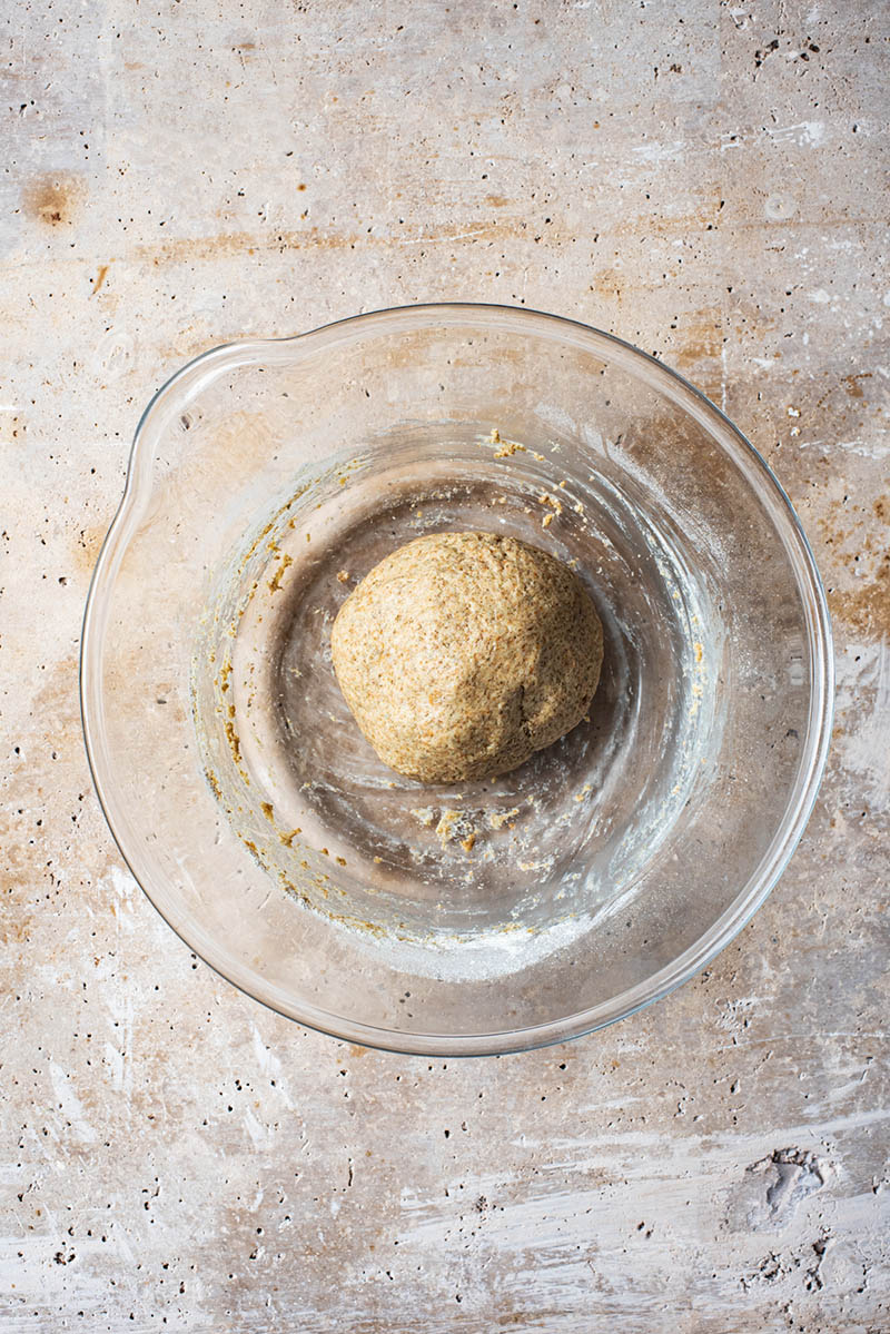Kneaded dough in a large glass bowl.