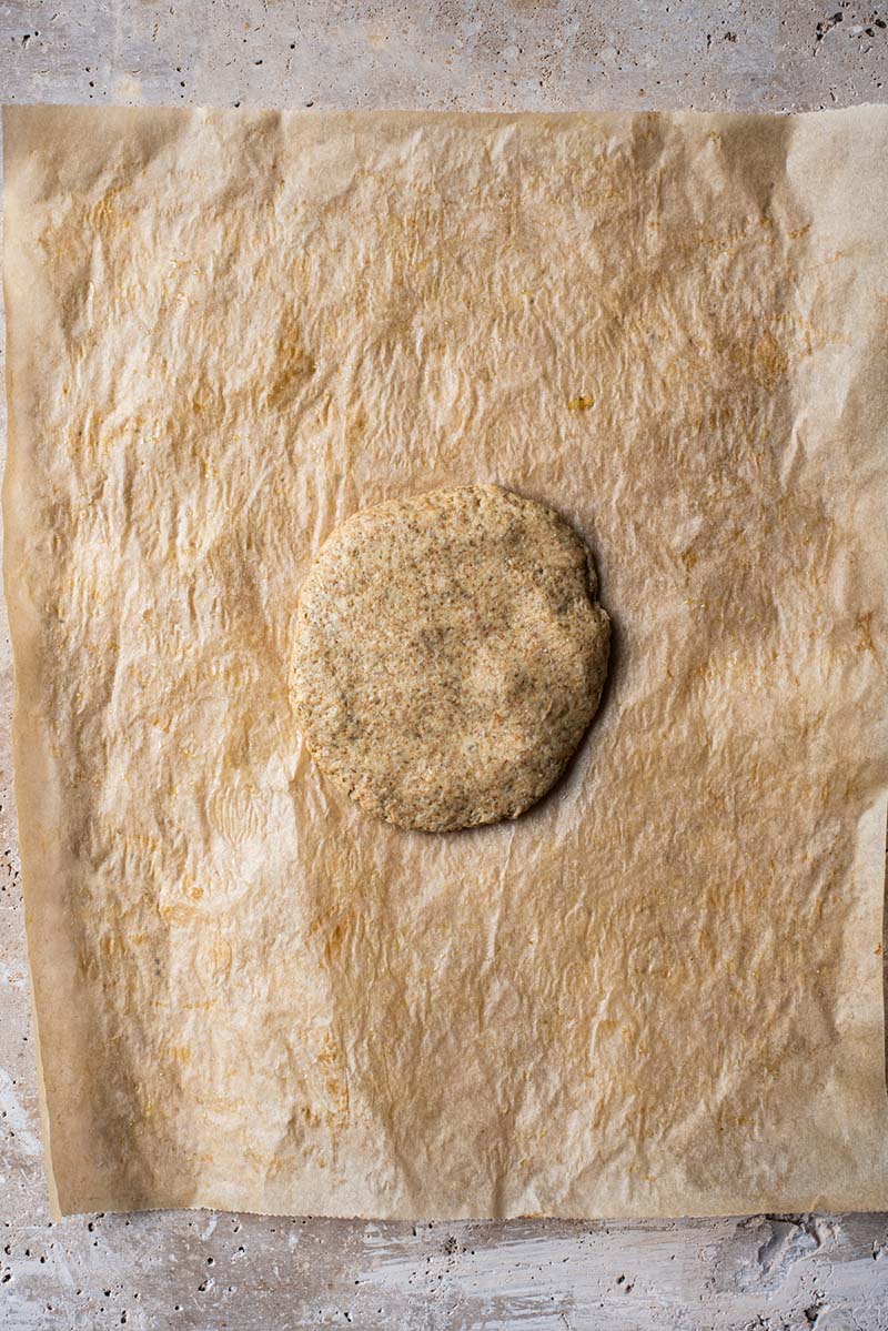 Half of the dough formed into a disc and placed onto a sheet of parchment.