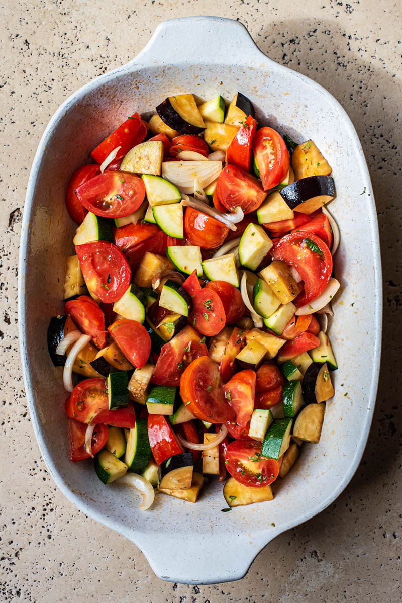 Vegetables cut and placed into a large roasting dish.