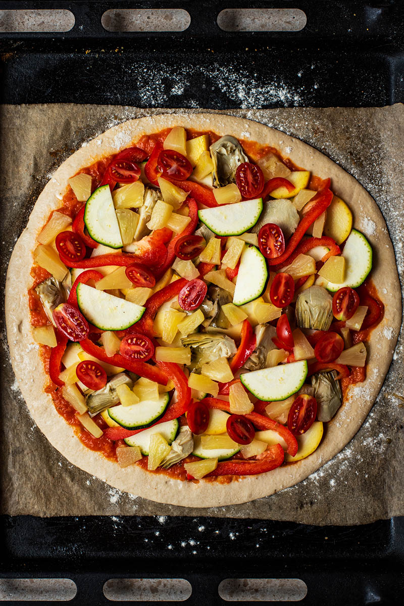Vegetable toppings added to the pizza crust.