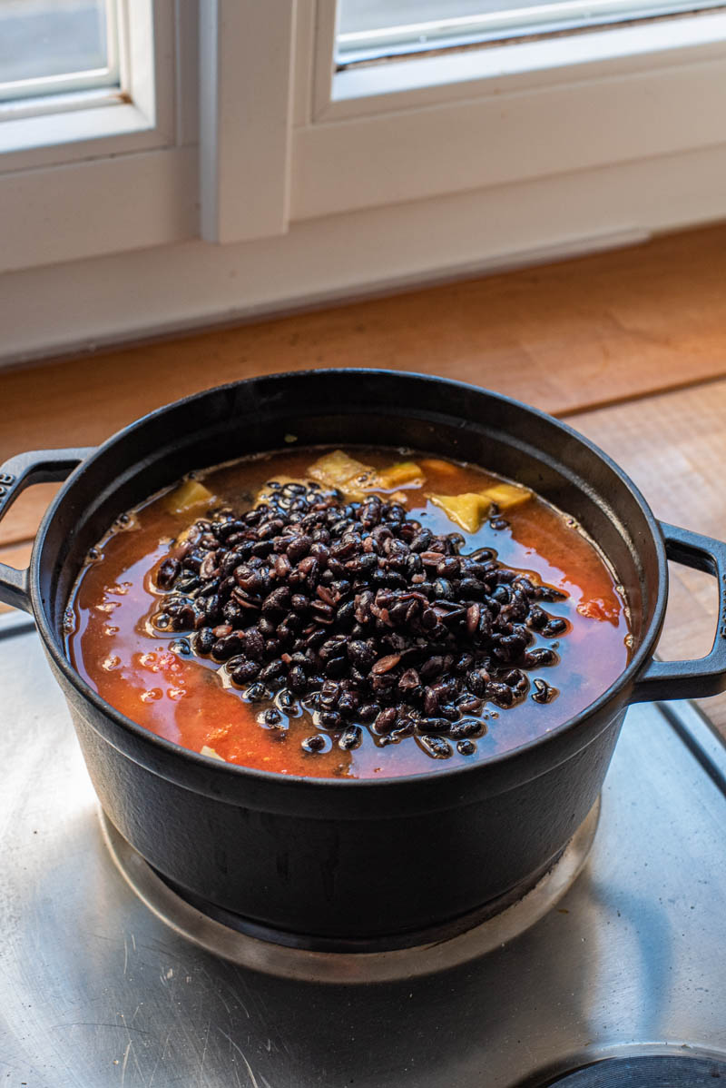 Canned tomatoes, water, and black beans added to the pot.