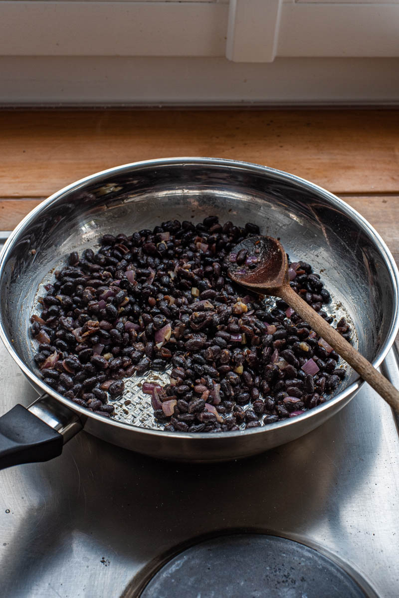 Finished spicy black beans in the pan, coated in the spices.