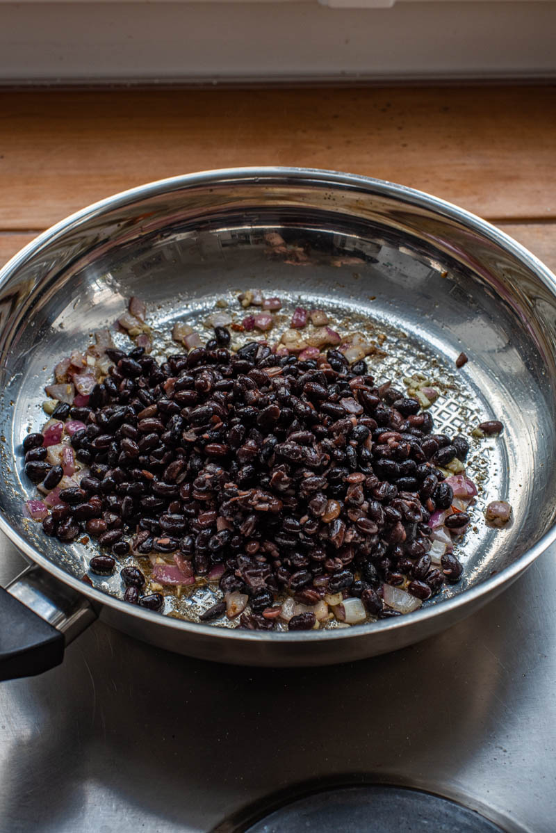 Black beans added to the pan.
